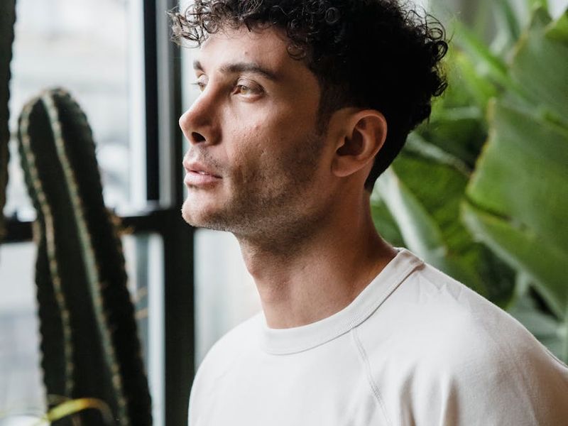 Wide shot of a person stretching in a spacious, minimalist room with natural light.